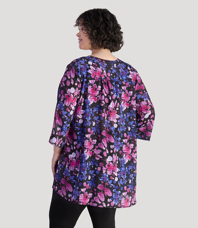 Plus size model, facing back, wearing JunoActive's BellaStyle Tunic Cover-up in floral elegance print.