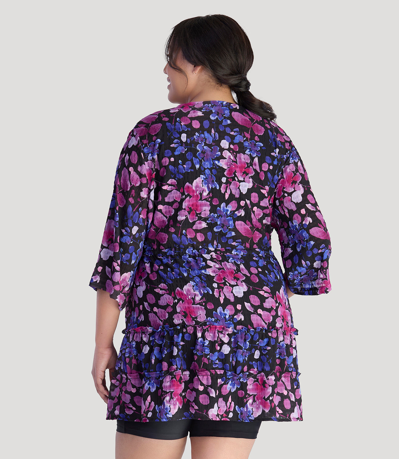 Plus size model, facing back, wearing JunoActive's BellaStyle Tie Front Tiered Cover-Up in floral elegance print.
