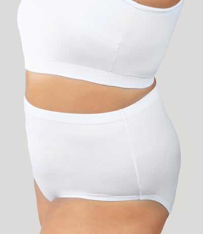 Plus size person, facing side and close up, wearing JunoActive's QuikWik Full Fit Brief plus size underwear in color white on a gray background.