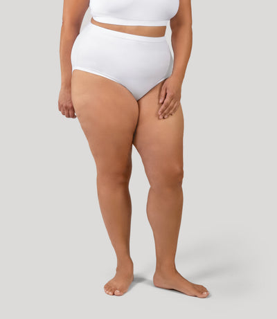 Plus size person, facing front, wearing JunoActive's QuikWik Full Fit Brief high-waisted plus size underwear in color white on a gray background.