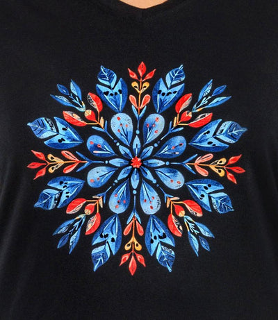 Close up of plus size Woman, facing front, wearing a JunoActive black plus size  long sleeve shirt with colorful scandi inspired snowflake design.