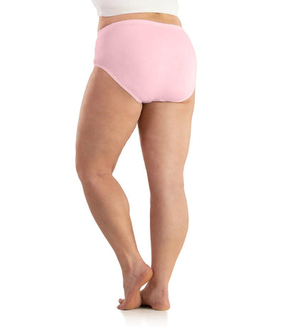 Bottom half of plus sized woman, back view, wearing JunoActive SupraKnit Briefs in petal pink. This brief fits to the waistline with a conservative leg opening.