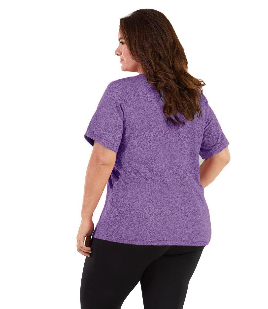 Plus size woman, facing back and looking left, wearing JunoActive plus size SoftWik V-Neck Tee in the color Heather Amethyst. She is wearing JunoActive Plus Size Leggings in the color black. 