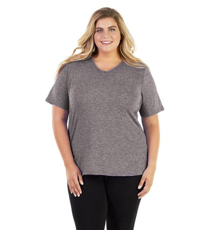 Plus size woman, facing front, wearing JunoActive plus size SoftWik V-Neck Tee in the color Heather Grey. She is wearing JunoActive Plus Size Leggings in the color black.