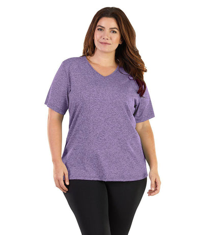 Plus size woman, facing front, wearing JunoActive plus size SoftWik V-Neck Tee in the color Heather Violet. She is wearing JunoActive Plus Size Leggings in the color black. 