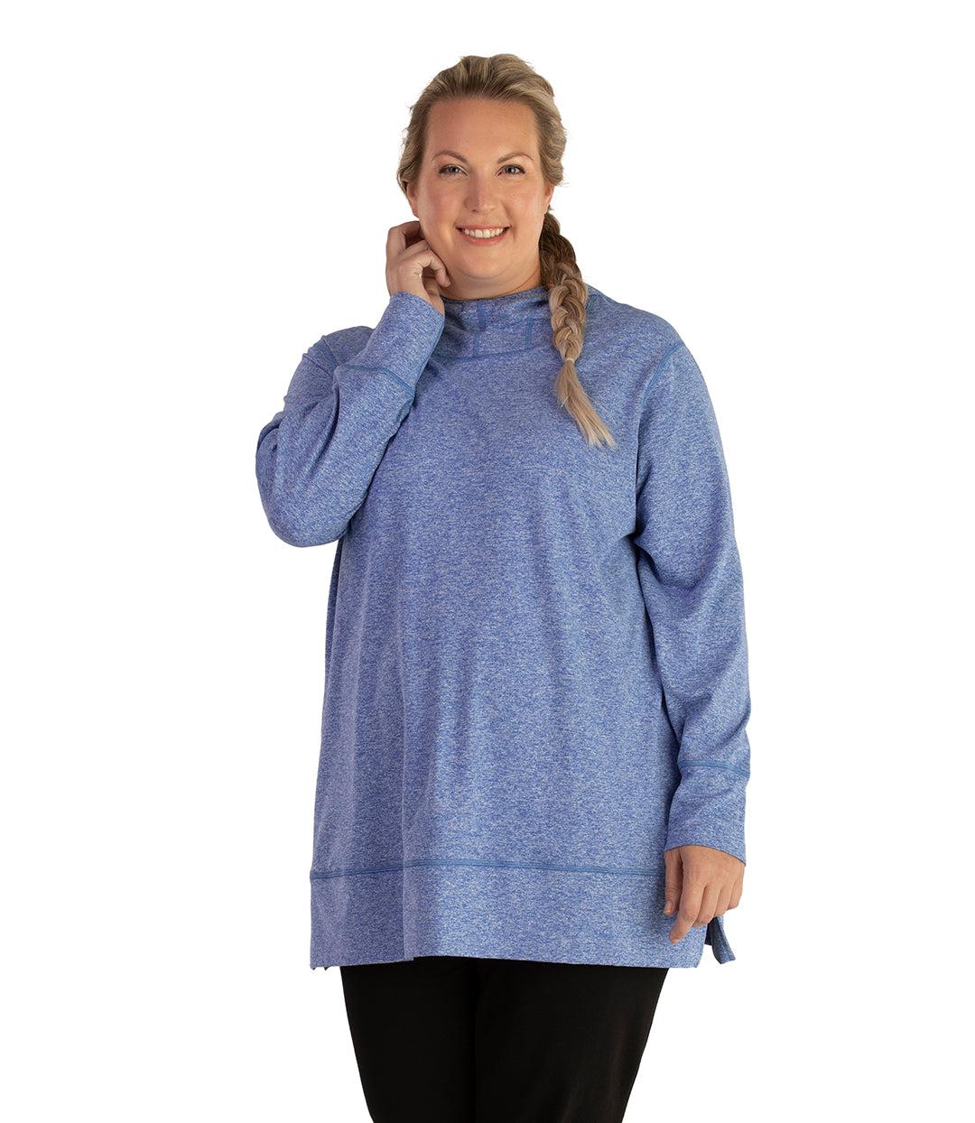 Plus size woman, facing front, wearing JunoActive plus size SoftWik Long Sleeve Hoodie in the color Heather Royal. She is wearing JunoActive Plus Size Leggings in the color Black.