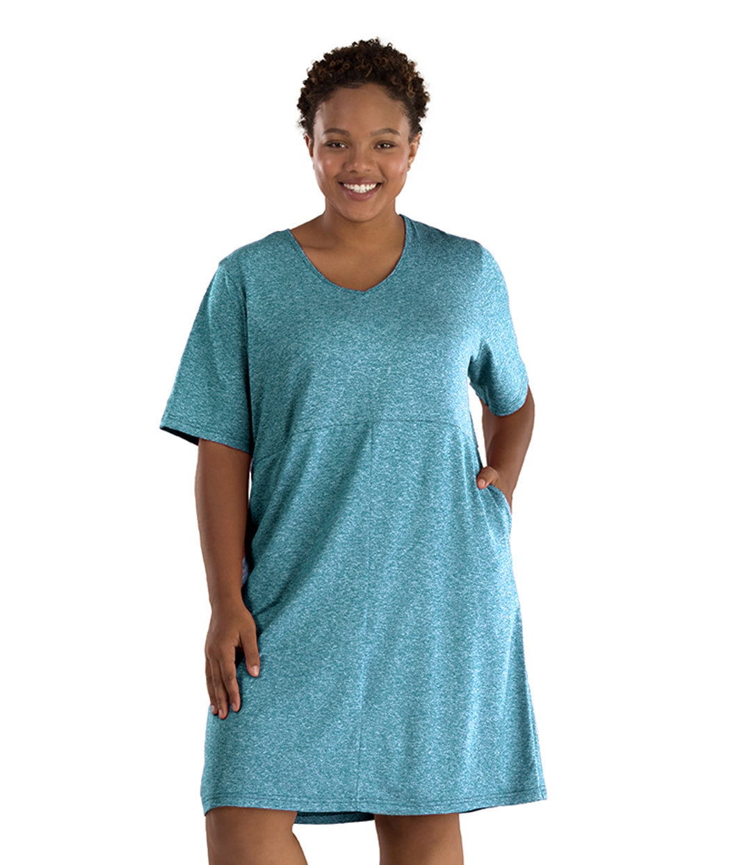 Plus size woman, facing front, wearing JunoActive plus size SoftWik Short Sleeve Dress in the color Heather Ocean. Her left hand is in the dress pocket. Her right hand is falling naturally at her side. The dress length hits at her knee. 