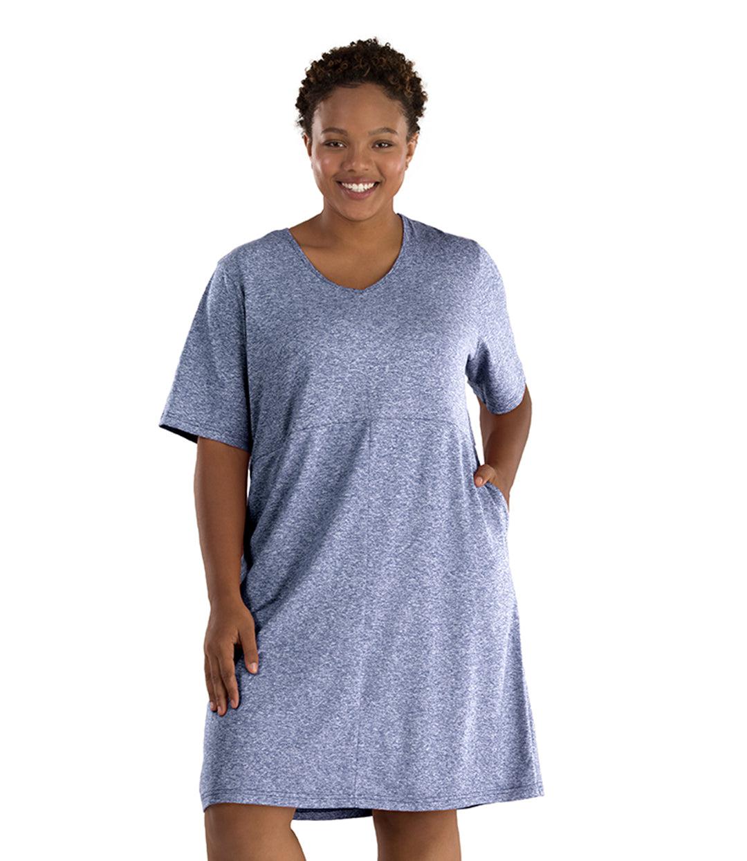 Plus size woman, facing front, wearing JunoActive SoftWik short sleeve dress with pockets. Sleeves are longer and fall at elbow. Hemline is at knees. The color is heather navy. 