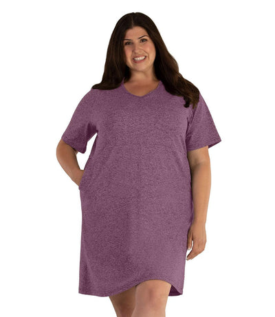 Plus size woman, facing front, wearing JunoActive SoftWik short sleeve dress with pockets. Sleeves are longer and just before elbow. Hemline is above knees. The color is heather merlot. 