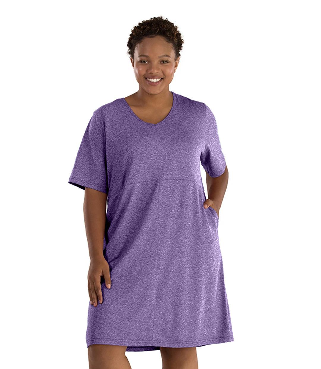 Plus size woman, facing front, wearing JunoActive SoftWik short sleeve dress with pockets. Sleeves are longer and just before elbow. Hemline is above knees. The color is heather violet. 