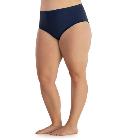 Bottom half of plus sized woman, facing front, wearing JunoActive QuikWik Comfort Briefs in navy. This brief fits just below the belly button with conservative leg opening.
