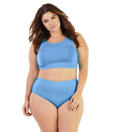 Plus size woman, facing front, wearing JunoActive plus size QuikWik Soft Control Bra Top in Columbia Blue. The woman is wearing a pair of coordinating QuikWik Comfort plus size Briefs in Columbia Blue. 