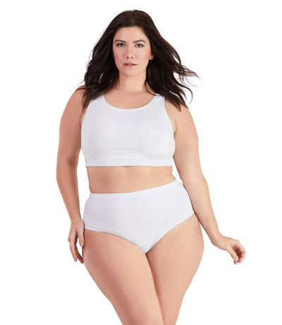 Plus size woman, facing front, wearing JunoActive plus size QuikWik Soft Control Bra Top in White. The woman is wearing a pair of coordinating QuikWik Comfort plus size Briefs in White.