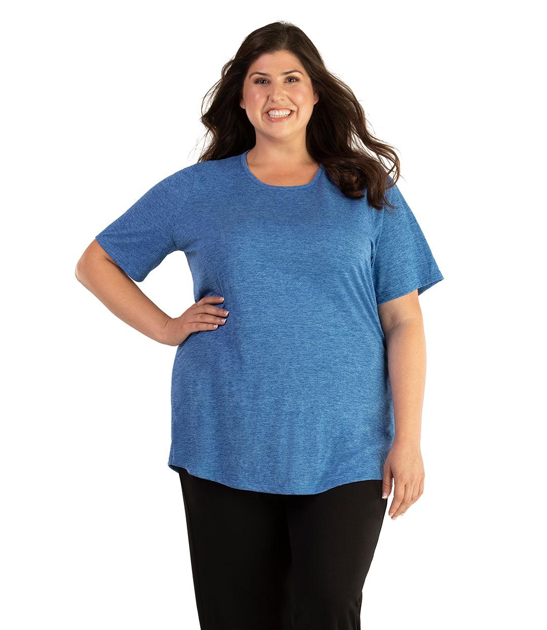 Plus size woman, facing front, wearing JunoActive plus size QuikLite Scoop Neck Short Sleeve top in the color Heather Blue. She is wearing JunoActive Plus Size Leggings in the color black. 