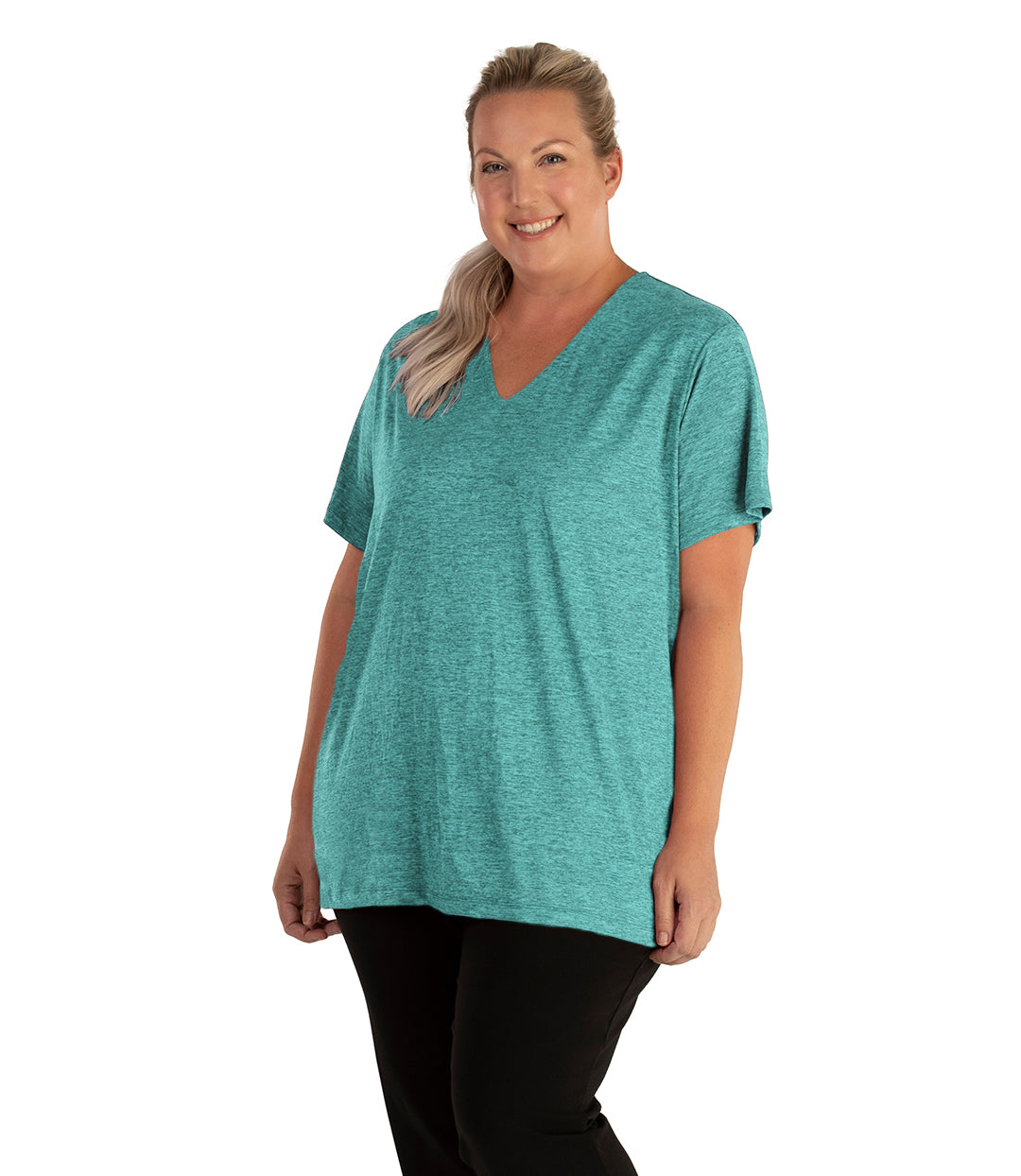 Plus size woman, facing front, wearing JunoActive plus size QuikLite V-Neck Short Sleeve top in the color Fern Green. She is wearing JunoActive Plus Size Leggings in the color black. 