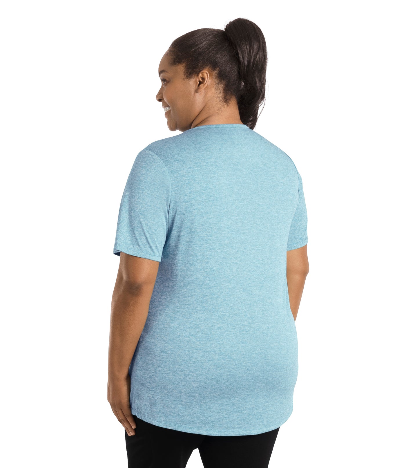 Plus size woman wearing JunoActive's SunLite Scoop Neck back view wearing black pants and hands by side in heather light blue.
