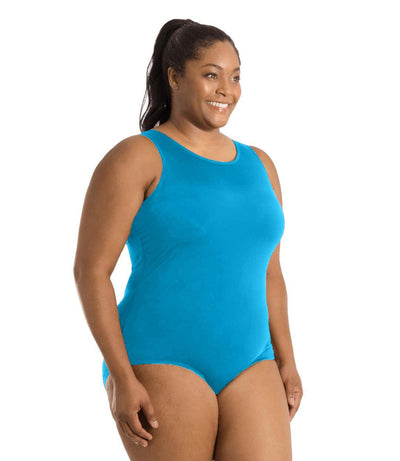 Plus size woman, side view, wearing JunoActive plus size QuikEnergy Spa Suit Turquoise. The suit is solid Turquoise, has a scoop neckline and conservative leg opening.