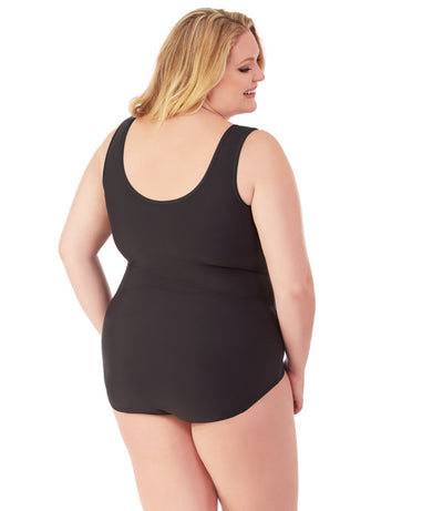 Plus size woman, back view, wearing JunoActive plus size QuikEnergy Spa Suit black tall.  The back of the suit is solid black with a scoop neckline.