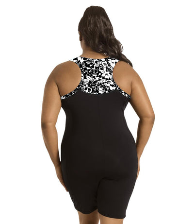 Plus size woman, back view, wearing JunoActive plus size QuikEnergy Racerback Zip Front Aquatard Hibiscus print. Neck binding, armhole binding, and racer back blocking is in a black and white floral print. The main body of the suit is solid black. The leg hits a few inches above the knee.