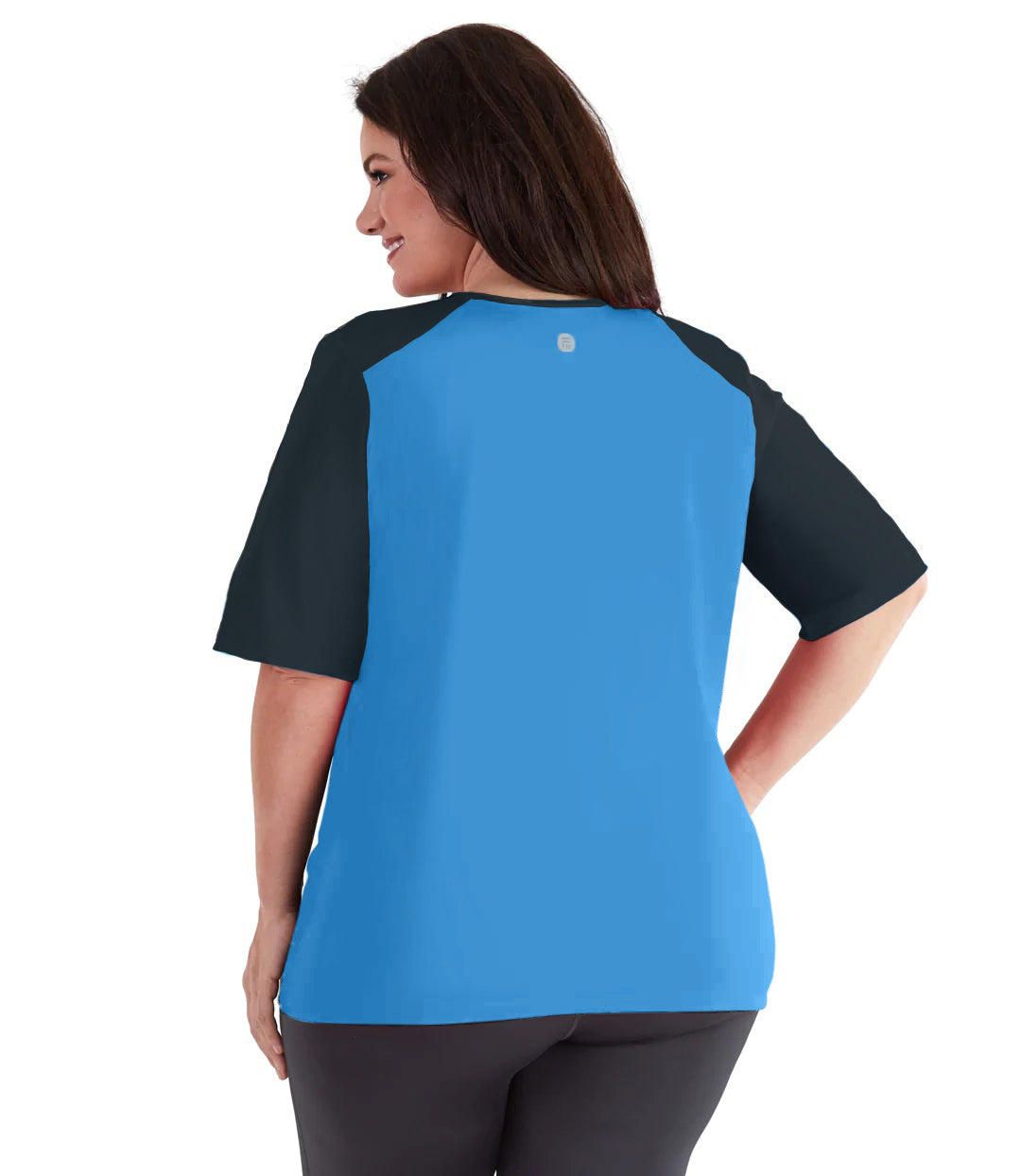 Plus size woman, facing back, wearing JunoActive's QuikEnergy Short Sleeve Swim and Sun Top. Sleeves are black and torso is turquoise. Sleeves come to model’s elbows. Her right hand is on her right hip.