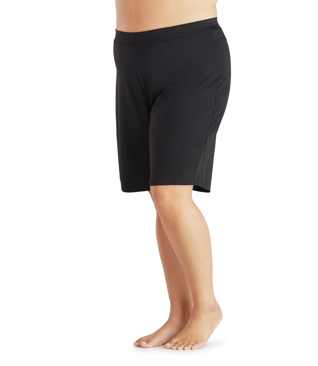Bottom half of plus size woman facing front, wearing a black JunoActive plus size swim and beach short with brief. The hem is just above the knees.