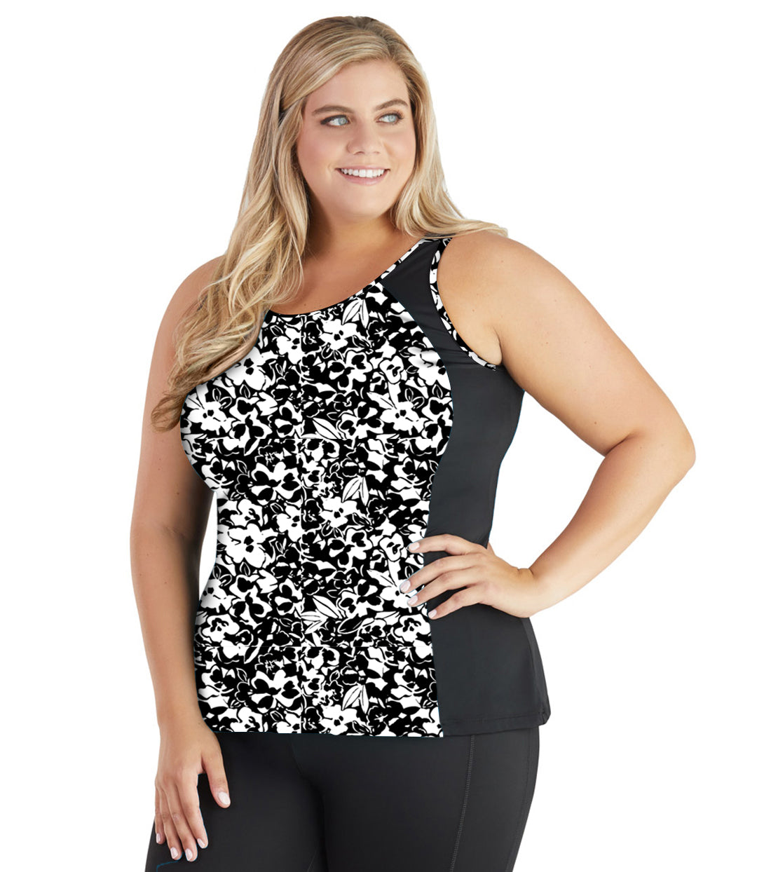 Plus size model, front view, wearing QuikEnergy Tankini Swim Top. The mid section in hibiscus print scoop neck and side panels in Black. 