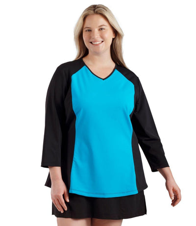 Plus size woman, facing front, wearing QuikEnergy  ¾ Sleeve Swim and Sun Top Black and Turq. Solid turquoise on the center torso and solid black colorblocking on the sleeves and waist .