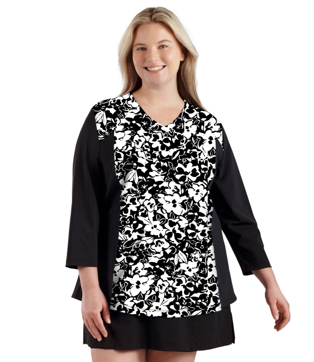 Plus size woman, facing front, wearing QuikEnergy ¾ Sleeve Swim and Sun Top Black and hibiscus print on the center torso and solid black colorblocking on the sleeves and waist.