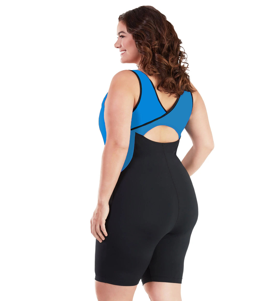 Plus size woman, back view, wearing JunoActive plus size AquaSport Crossback Aquatard Pacific Blue Black. The overlapping crossback and side blocking detail of the tanksuit is blue. The main body of the suit is solid black, keyhole opening at the mid-back. The leg hits a few inches above the knee.
