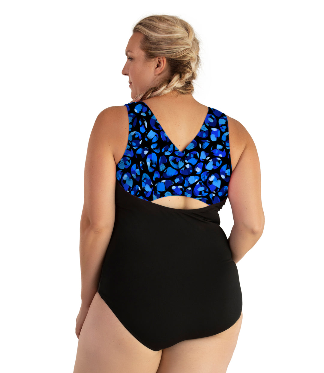 Plus size woman, back view, wearing JunoActive plus size AquaSport Crossback Tanksuit Ocean Blues Print Black. The crossback shoulder detail of the tanksuit has a multi colored blue bubble print. The main body of the suit is solid black, keyhole opening at the mid-back.