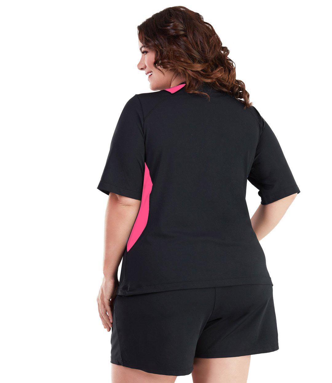 Plus size woman, back view, wearing AquaSport Colorblock Swim Tee Pink and Black. Pink colorblocking on waist and shoulders. Long cover short sleeves meeting at the elbow. 