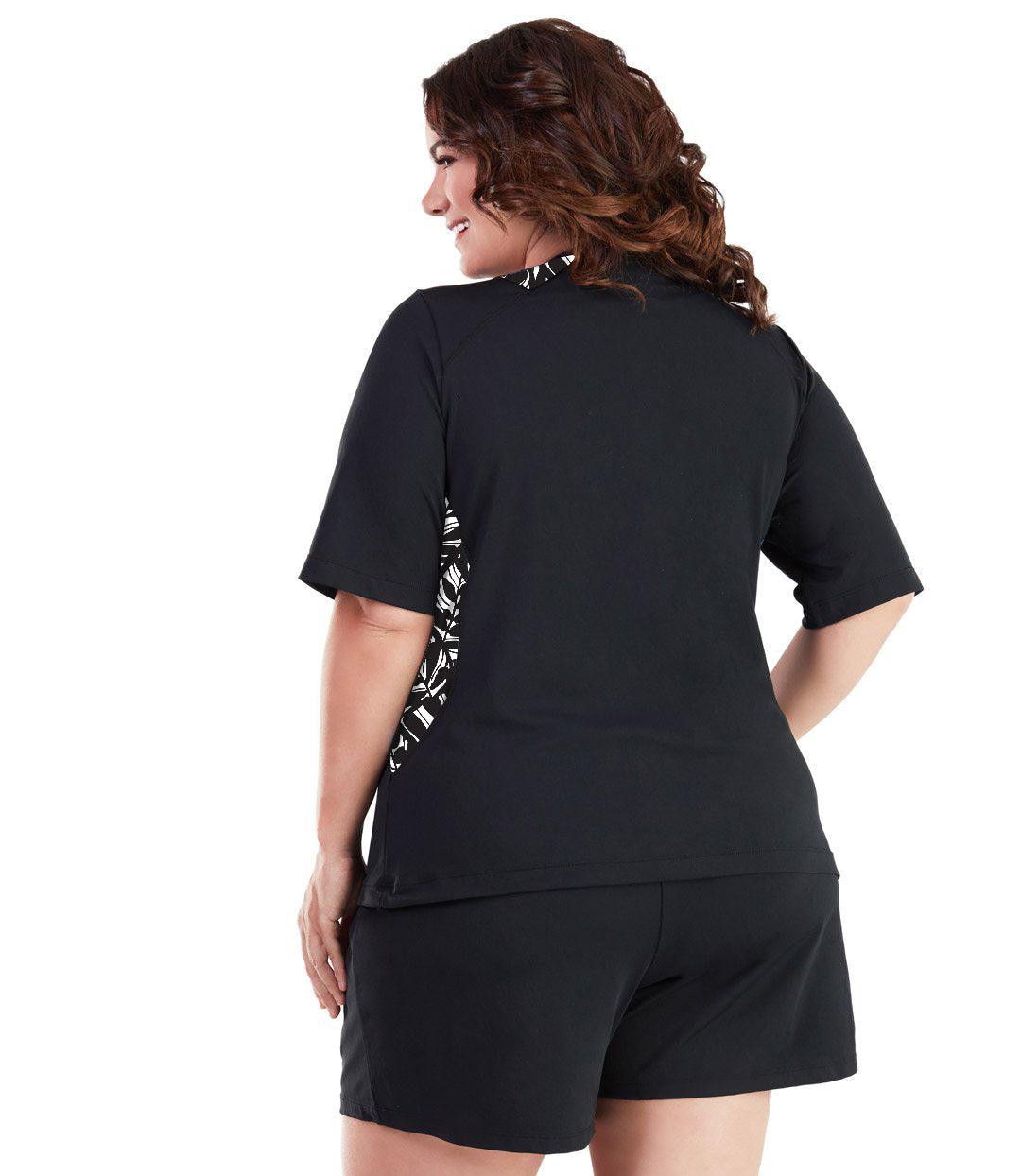 Plus size woman, back view, wearing AquaSport Colorblock Swim Tee Tropical Black. Tropcial black and white colorblocking on waist and shoulders. Long cover short sleeves meeting at the elbow. 