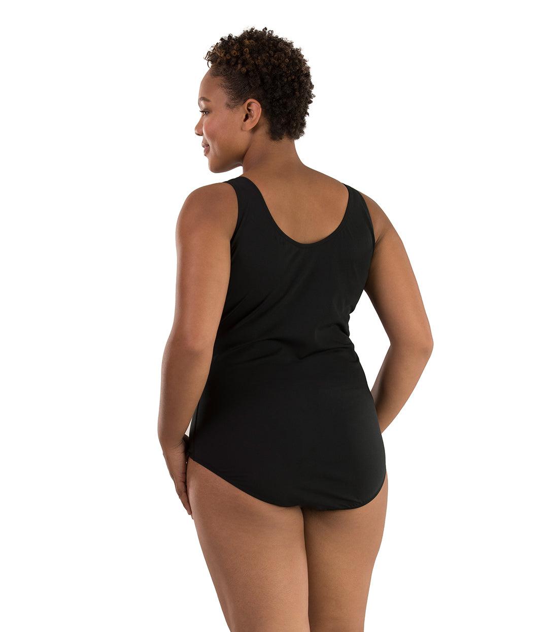 Plus size woman, back view, wearing JunoActive plus size Aquasport Colorblock Tanksuit Purple and Black.  The back of the suit is solid black with a scoop neckline.