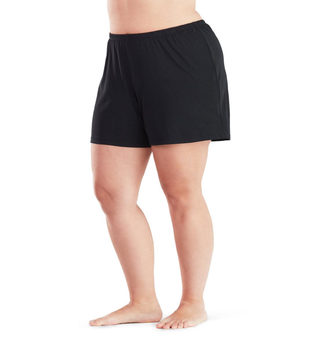 Plus size woman, facing front, wearing AquaSport Swim Short with Brief in solid black. Loose leg opening landing mid-thigh.