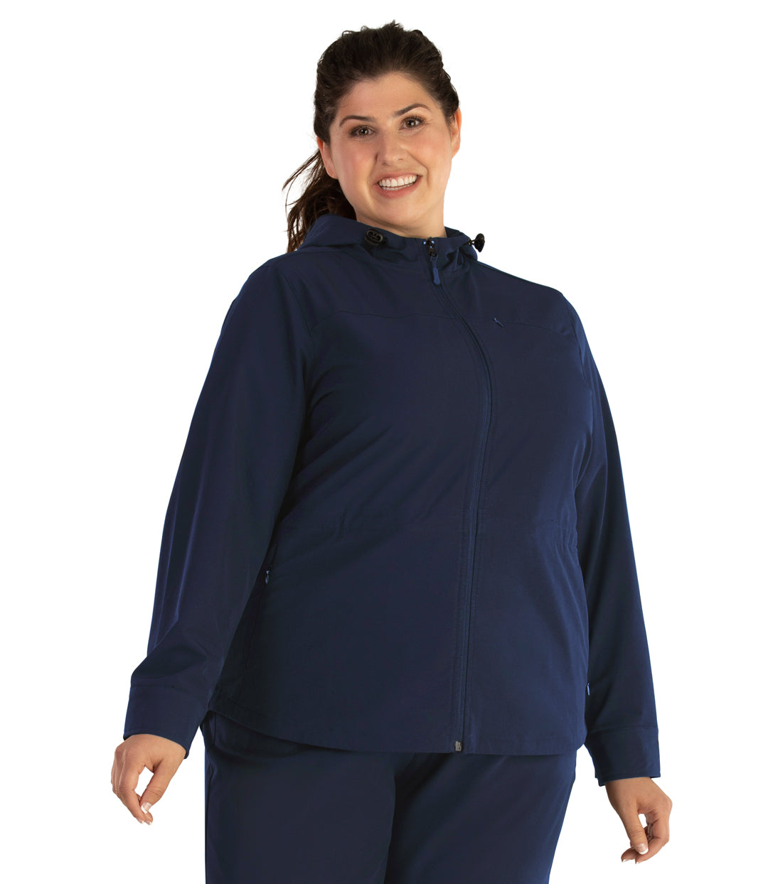 Plus size woman, front view, wearing a JunoActive plus size Hiking and Travel Jacket in navy blue. The jacket has a hood, zip front closure and side zip pockets. The length of the plus size jacket hits at the hips.