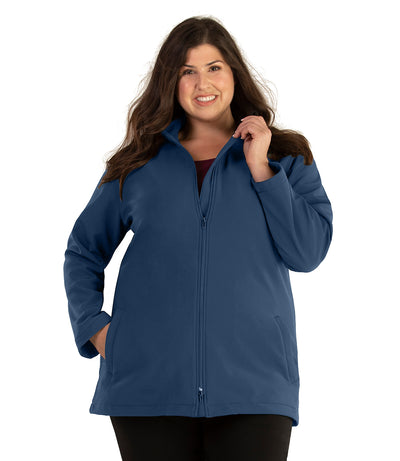 Plus size woman, front view, wearing a JunoActive plus size Mock Neck Softshell Jacket in Tiempo Teal. The jacket has a mock neck collar, zip front closure and side pockets. The length of the plus size jacket hits just below the hips.
