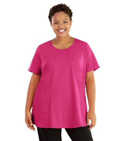 Plus size woman, facing front, wearing JunoActive plus size Stretch Naturals Lite Swing Top in the color Poppy Pink. She is wearing JunoActive Plus Size Leggings in the color black. 