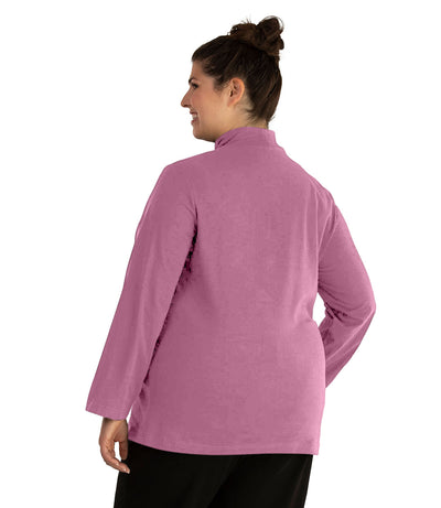 Plus size woman, facing back, wearing JunoActive plus size Stretch Naturals Lite Mock Neck Top in the color Mulberry. She is wearing JunoActive Plus Size Leggings in the color Black.