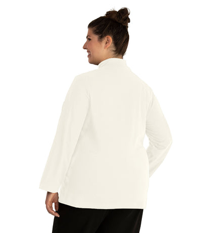 Plus size woman, facing back looking left, wearing JunoActive plus size Stretch Naturals Lite Mock Neck Top in the color Winter White. She is wearing JunoActive Plus Size Leggings in the color Black.