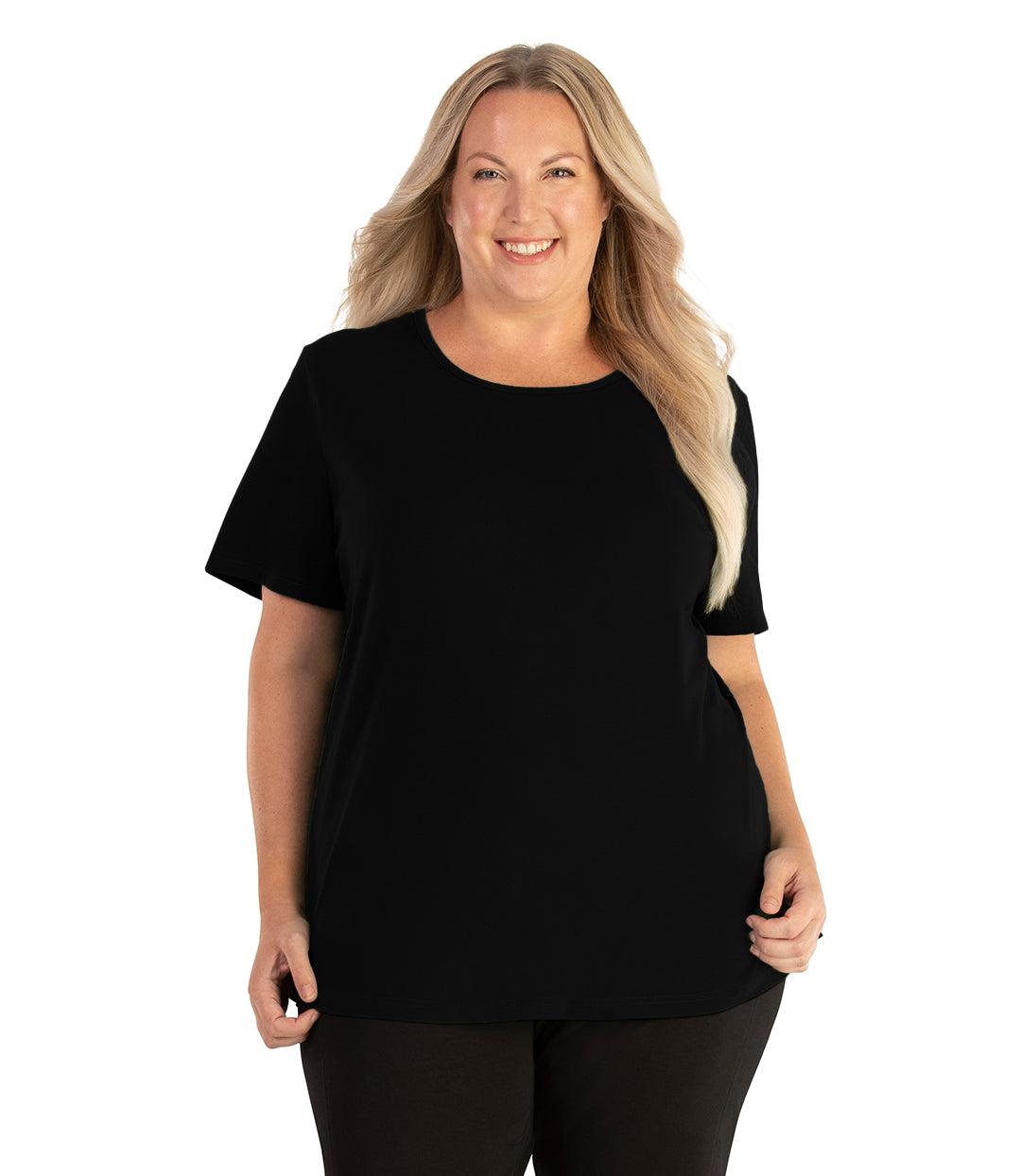 Plus size woman, facing front, wearing JunoActive plus size Stretch Naturals Lite Short Sleeve Scoop Neck Top in the color Black. She is wearing JunoActive Plus Size Leggings in the color black. 