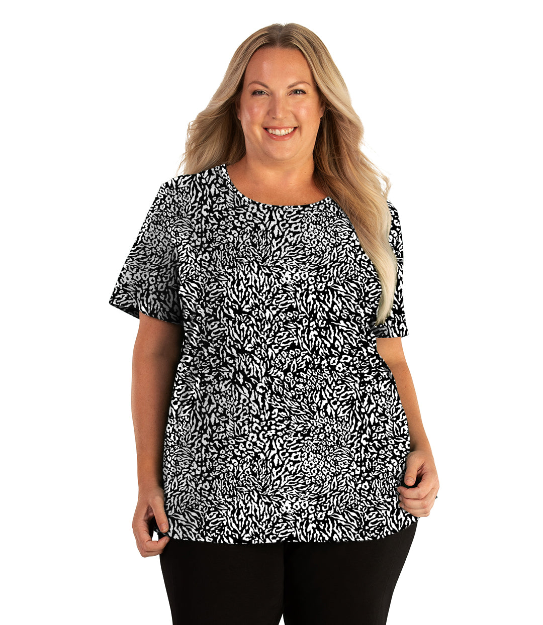 Plus size woman, facing front, wearing JunoActive plus size Stretch Naturals Lite Short Sleeve Scoop Neck Top in the color Wild Print. She is wearing JunoActive Plus Size Leggings in the color black. 