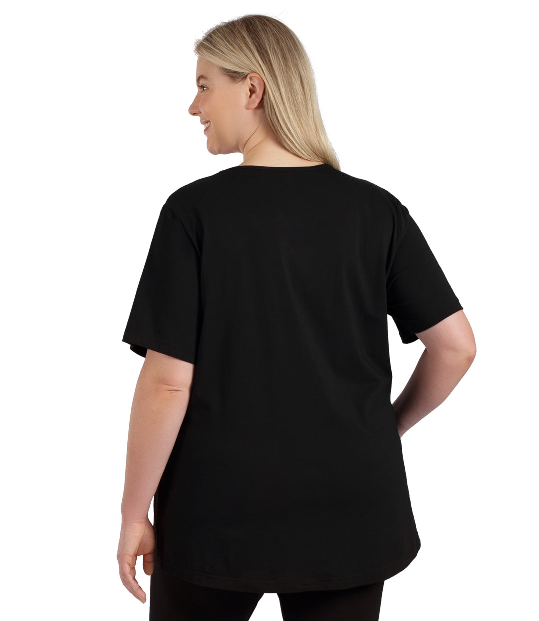 Plus size woman, facing to the back, wearing JunoActive plus size Stretch Naturals Lite Short Sleeve V-Neck Top in the color Black.  She is wearing JunoActive Plus Size Leggings in the color black. 
