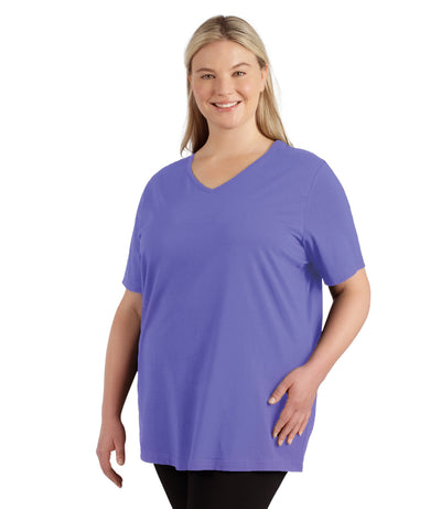 Plus size woman, facing front, wearing JunoActive plus size Stretch Naturals Lite Short Sleeve V-Neck Top in the color Merri Perri.   She is wearing JunoActive Plus Size Leggings in the color black. 