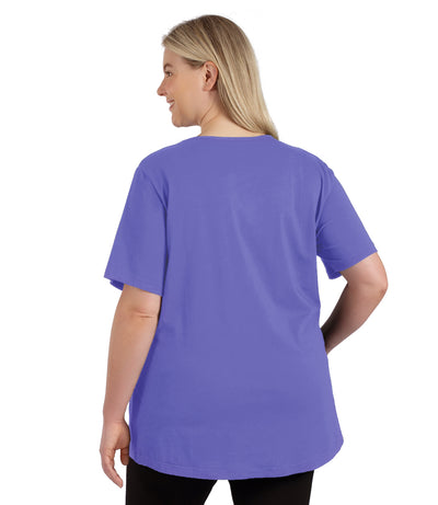 Plus size woman, facing to the back, wearing JunoActive plus size Stretch Naturals Lite Short Sleeve V-Neck Top in the color Merri Perri.  She is wearing JunoActive Plus Size Leggings in the color black. 
