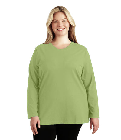 Plus size woman, facing front, wearing JunoActive’s Stretch Naturals Lite Long sleeve scoop neck top, in color aloe green, with her hands by her side. Leggings in black. 