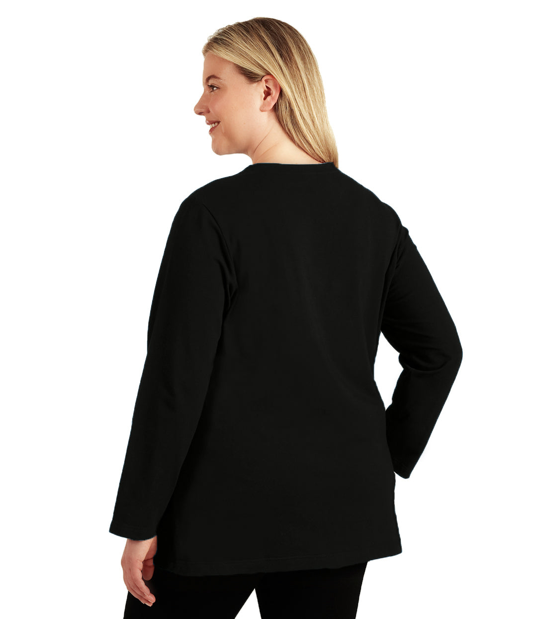Plus size woman, facing back, wearing JunoActive’s Stretch Naturals Lite Long sleeve scoop neck top, in color black, with one hand by her side and right arm on right him. Leggings in black. 