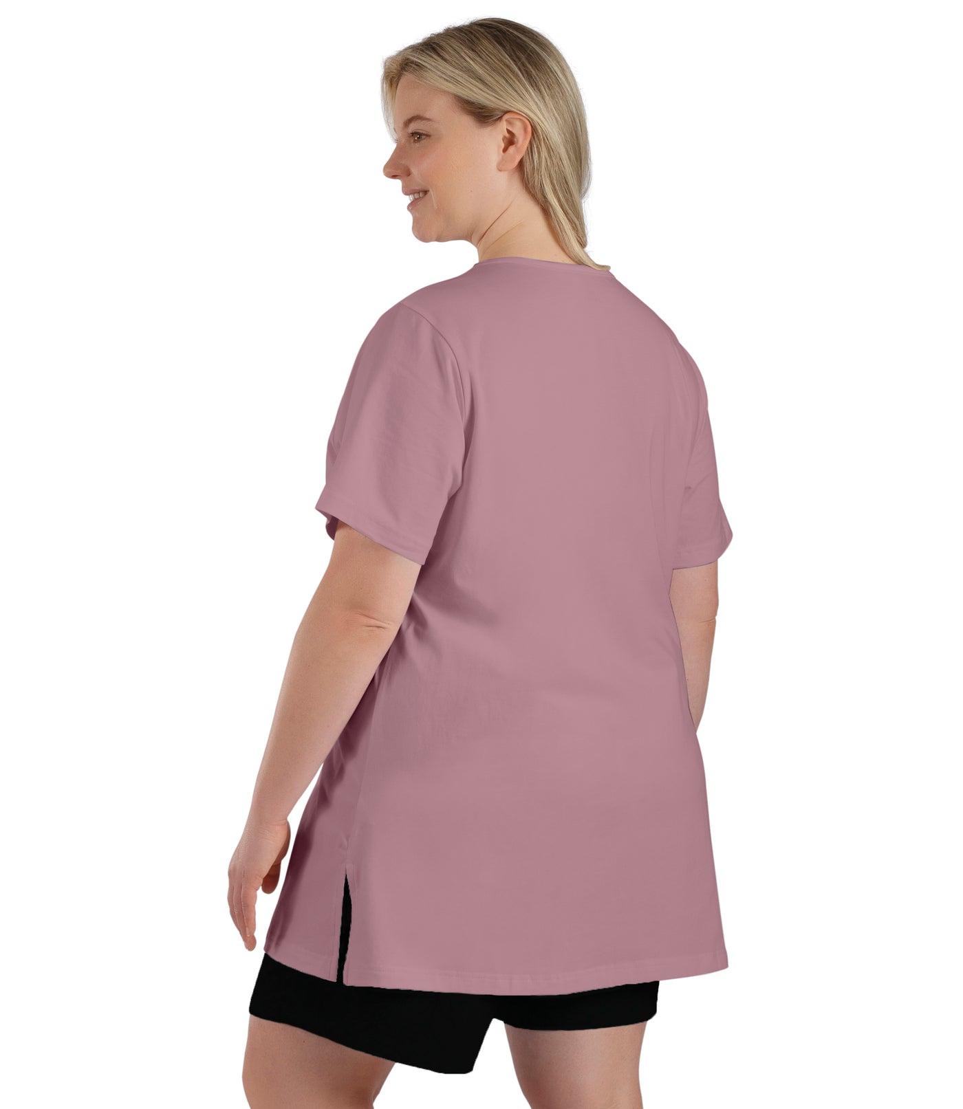 Plus size woman, facing back, wearing JunoBliss V-Neck Short Sleeve Top in rose color. The length comes past crotch and is loose fitted.  Split in side hem. 