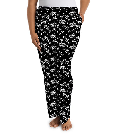 Plus size woman wearing JunoActive's JunoBliss pocketed sleep pants in fresh gardenia print in colors white and black. Model is facing forward. 