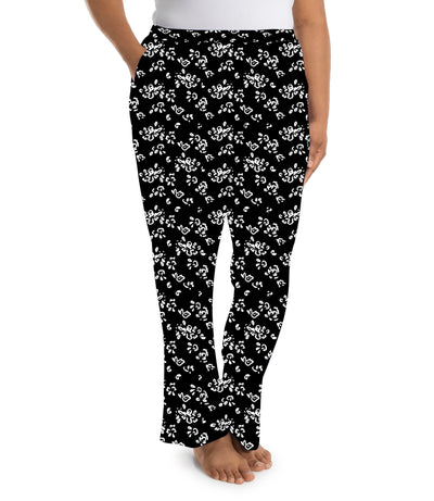 Plus size woman wearing JunoActive's JunoBliss pocketed sleep pants in fresh gardenia print in colors white and black. Model is facing side. 