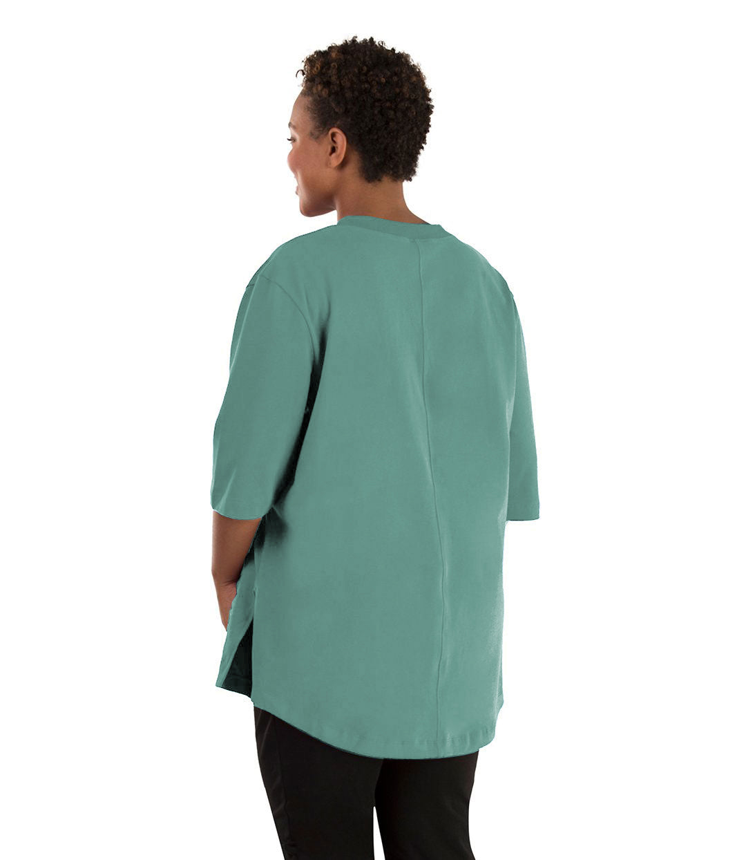 Plus size woman, facing back left, wearing JunoActive plus size Legacy Cotton Casual Tunic in the color lichen green. She is wearing JunoActive Plus Size Leggings in the color black.